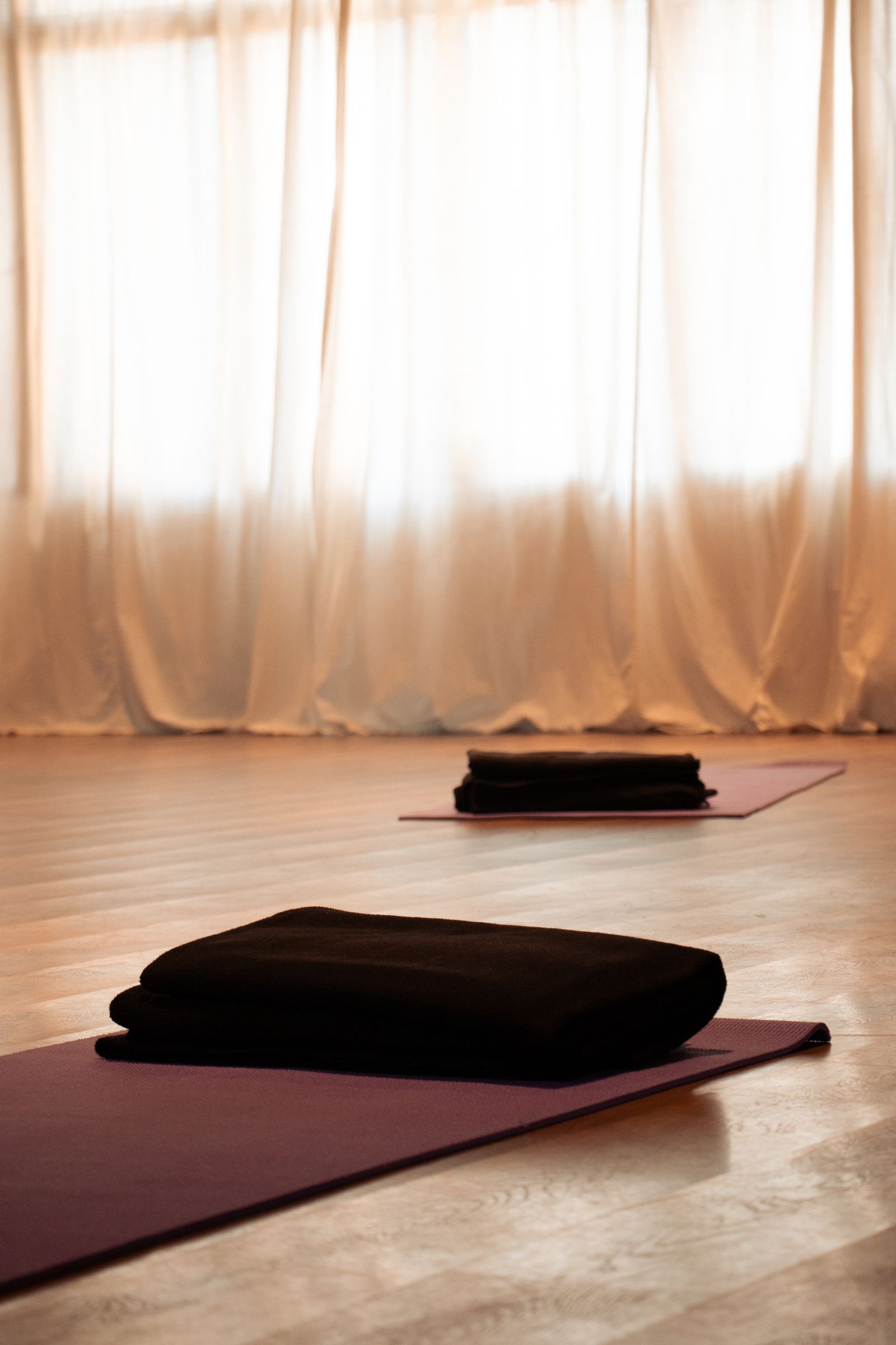 A mat and folded blanket laid out in the studio before class